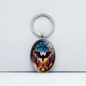 Detailed view of an oval glass cabochon keychain with a gothic black bat design