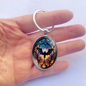 Detailed macro view of an oval gothic bat keychain with a stained glass effect pendant