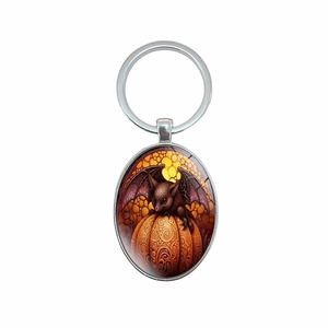Halloween oval pendant keychain featuring a bat on a pumpkin with silver metal ring