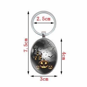 Halloween oval keychain with pumpkin castle design in metal frame, 7.5cm length