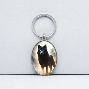 Porte-clés ovale avec illustration de loup noir sur fond en métal brossé