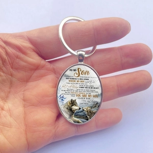 Porte-clés punk loup ovale avec message pour fils tenu dans la main d'une personne