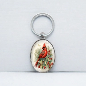 Vintage oval silver keychain featuring a red cardinal on a festive pine branch
