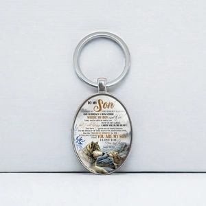 Porte-clés ovale en argent avec motif loup et message d'une mère à son fils sur fond blanc