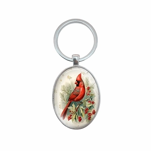Vintage silver metal keychain with oval pendant featuring a red cardinal on holly branches