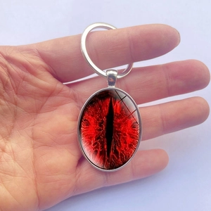 Oval silver keychain with blood red cat eye pattern pendant and metal ring accessory