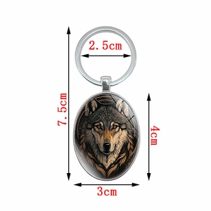 Oval silver metal keychain with artistic wolf pendant including size measurements