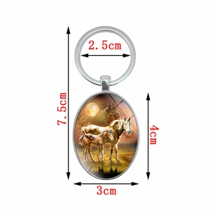 Oval silver metal keychain featuring horses at sunset with 7.5cm total length