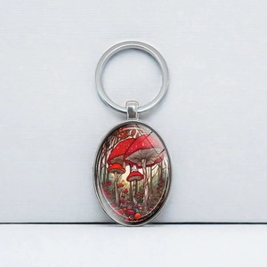 Elegant silver keychain with red mushroom forest oval pendant and metallic key ring