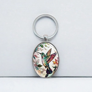 Oval hummingbird keychain with colorful floral illustration and silver metal keyring pendant