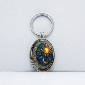 Vintage oval metal keychain with sun and moon pattern on dark blue starry background