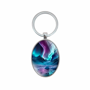 Oval keychain featuring aurora borealis landscape under glass with metal ring