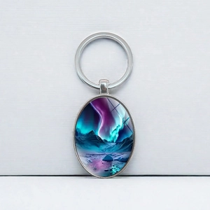 Northern Lights oval metal keychain with snowy mountain landscape in silver frame