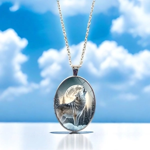 Detailed close-up of oval wolf howling at the moon pendant with silver metal chain