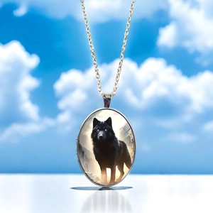 Macro detail of oval locket necklace featuring a black wolf artwork on metal pendant