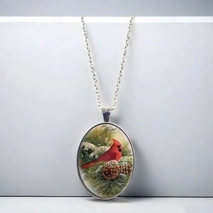Vintage oval pendant necklace featuring a cardinal bird on pine branches with silver chain