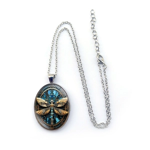 Oval silver pendant necklace featuring a vintage dragonfly motif on blue glass pattern
