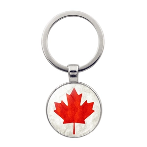 Detalle de primer plano del llavero bandera de Canadá con hoja de arce roja sobre metal