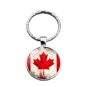 Vintage Canada flag keychain featuring a red maple leaf on a silver round glass pendant
