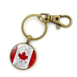 Detail of vintage bronze Canada flag keychain with glass dome and lobster clasp