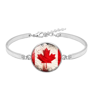 Detail of silver chain bracelet featuring a Canadian flag maple leaf glass pendant