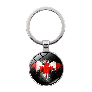 Detalle de llavero de bandera de Canadá plateado con hoja de maple bajo domo cristal