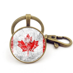 Detailed close-up of Canada flag keychain with antique bronze lobster clasp and round glass