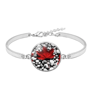 Detailed view of silver bracelet featuring a red maple leaf motif time gem cabochon