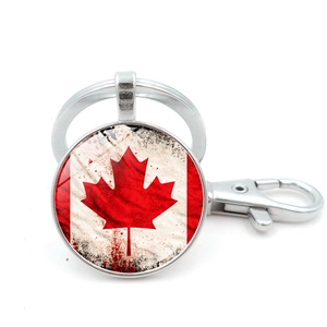 Close-up of a vintage Canada flag keychain with a metallic lobster clasp and round pendant