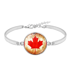 Silver bracelet featuring Canada flag red maple leaf under round glass cabochon charm