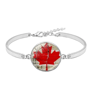 Minimalist silver bracelet with Canada flag glass cabochon on a clean white background