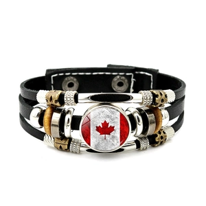 Close-up of multilayer leather bracelet featuring a Canada flag glass charm and metal beads