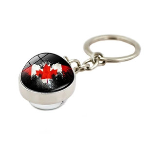 Detail view of a double-sided spherical Canada flag keychain with silver metal chain