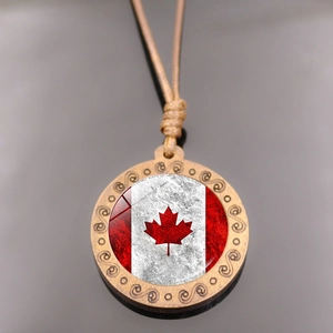 Close-up of vintage Canada flag pendant featuring wood frame and glass cabochon details