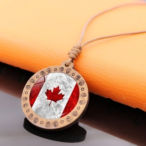 Detailed close-up of a rustic wooden pendant featuring a Canadian flag gemstone on woven cord