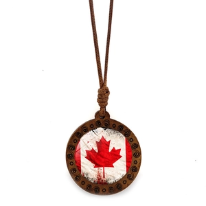 Detail of a vintage wooden necklace featuring a Canadian flag maple leaf pendant on white back