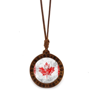 Close-up of wooden pendant with Canada flag maple leaf on a brown wax cord necklace