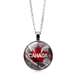 Detail of a glass dome Canada flag pendant necklace with maple leaf and brick pattern