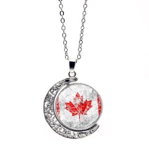 Detail of moon-shaped pendant featuring the Canada flag with intricate hollow-carved patterns