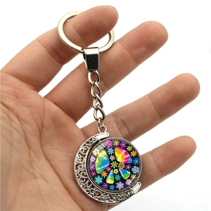 Detailed view of silver crescent moon keychain featuring a colorful rainbow peace sign pendant
