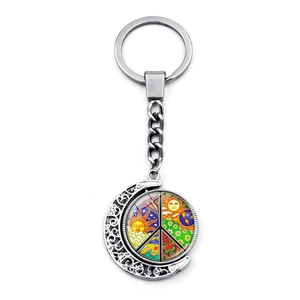 Detailed view of silver crescent moon keychain with rotating peace symbol charm