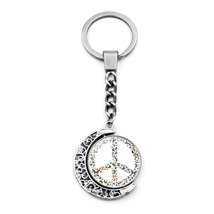 Detail of a rotating peace sign pendant with colorful butterflies and silver moon