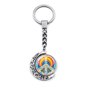 Close-up of silver crescent moon keychain with rainbow peace sign rotating pendant