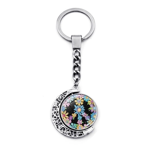 Silver crescent moon keychain with rotating peace sign floral pendant and metal ring