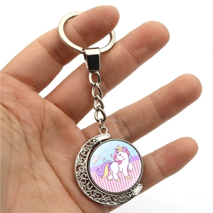 Detail view of rotating moon keychain with cute unicorn charm in polished silver finish