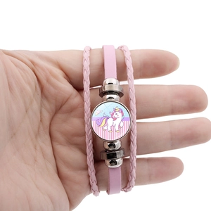 Détail d'un bracelet licorne en cuir rose avec perles multicouches et dôme en verre