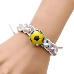 Detail of hand-woven colorful sports bracelet featuring a yellow soccer ball snap button