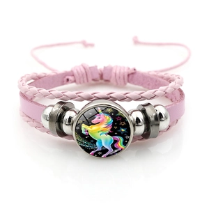 Détail d'un bracelet tressé rose multicouche avec cabochon en verre à motif licorne