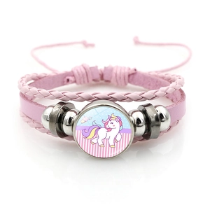 Vue détaillée du bracelet en cuir tressé rose avec breloque licorne en dôme de verre