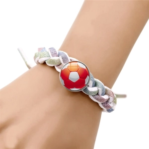 Detail of pink and green braided bracelet featuring a soccer ball snap button on wrist